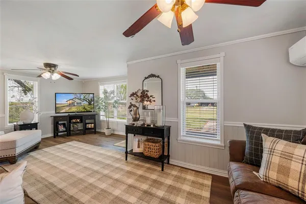 a living room with furniture and a flat screen tv with wooden floor