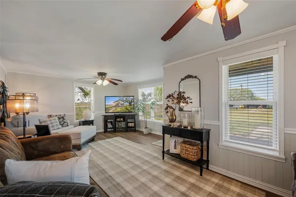 a living room with furniture and a flat screen tv with wooden floor