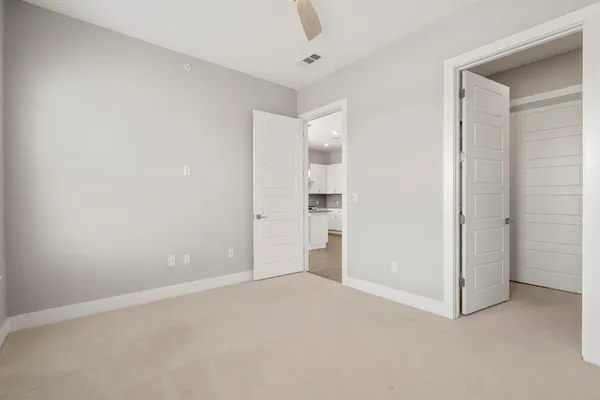 an empty room with a window and ceiling fan
