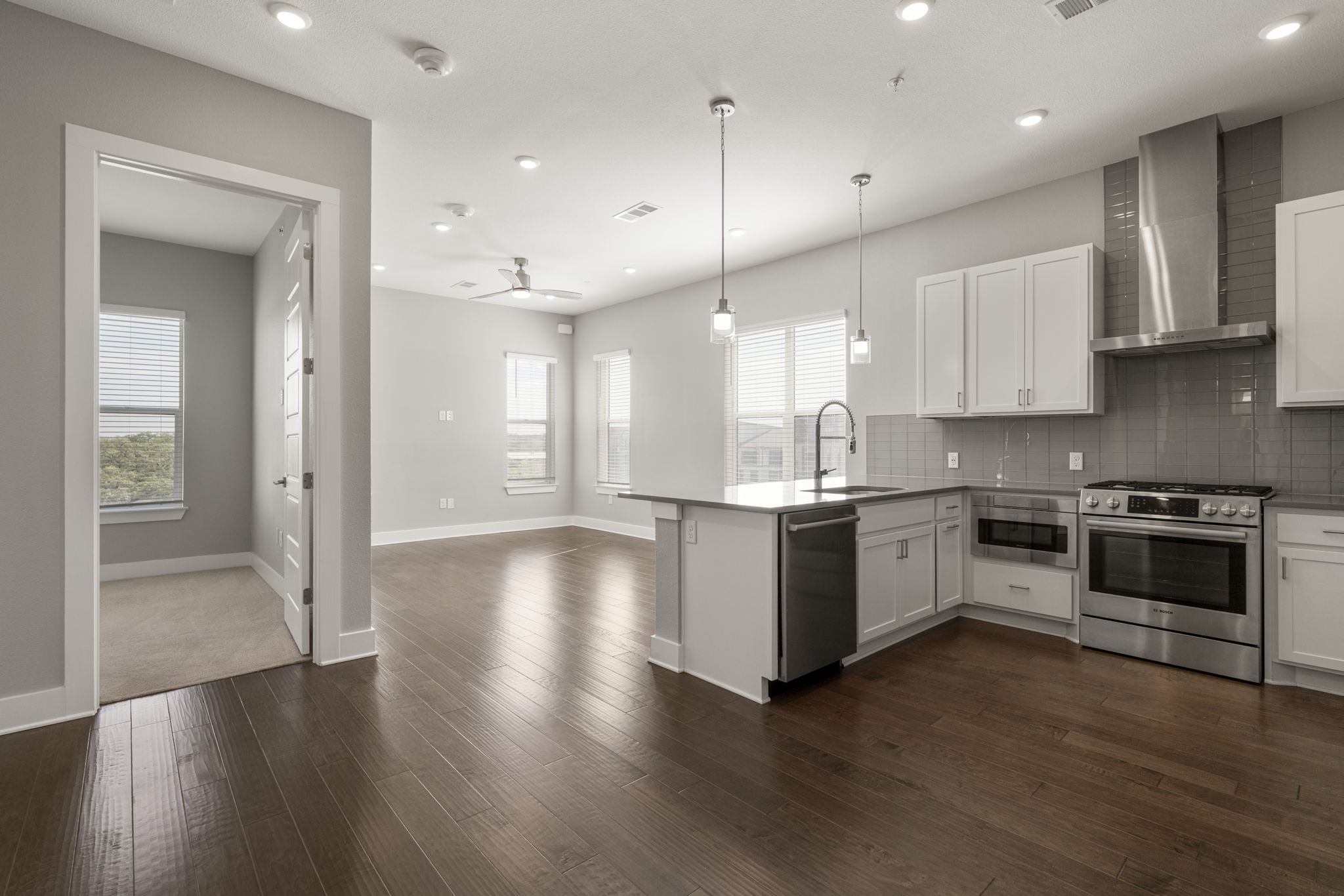 4501 Jackson Avenue, Unit 5205 Austin, TX 78731 - Photo 3 of 40 Kitchen featuring white cabinetry, stainless steel appliances, tasteful backsplash, and a peninsula