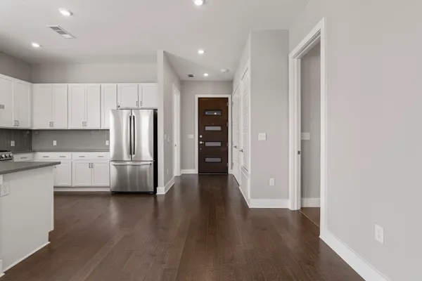 a kitchen with stainless steel appliances a refrigerator and wooden floor