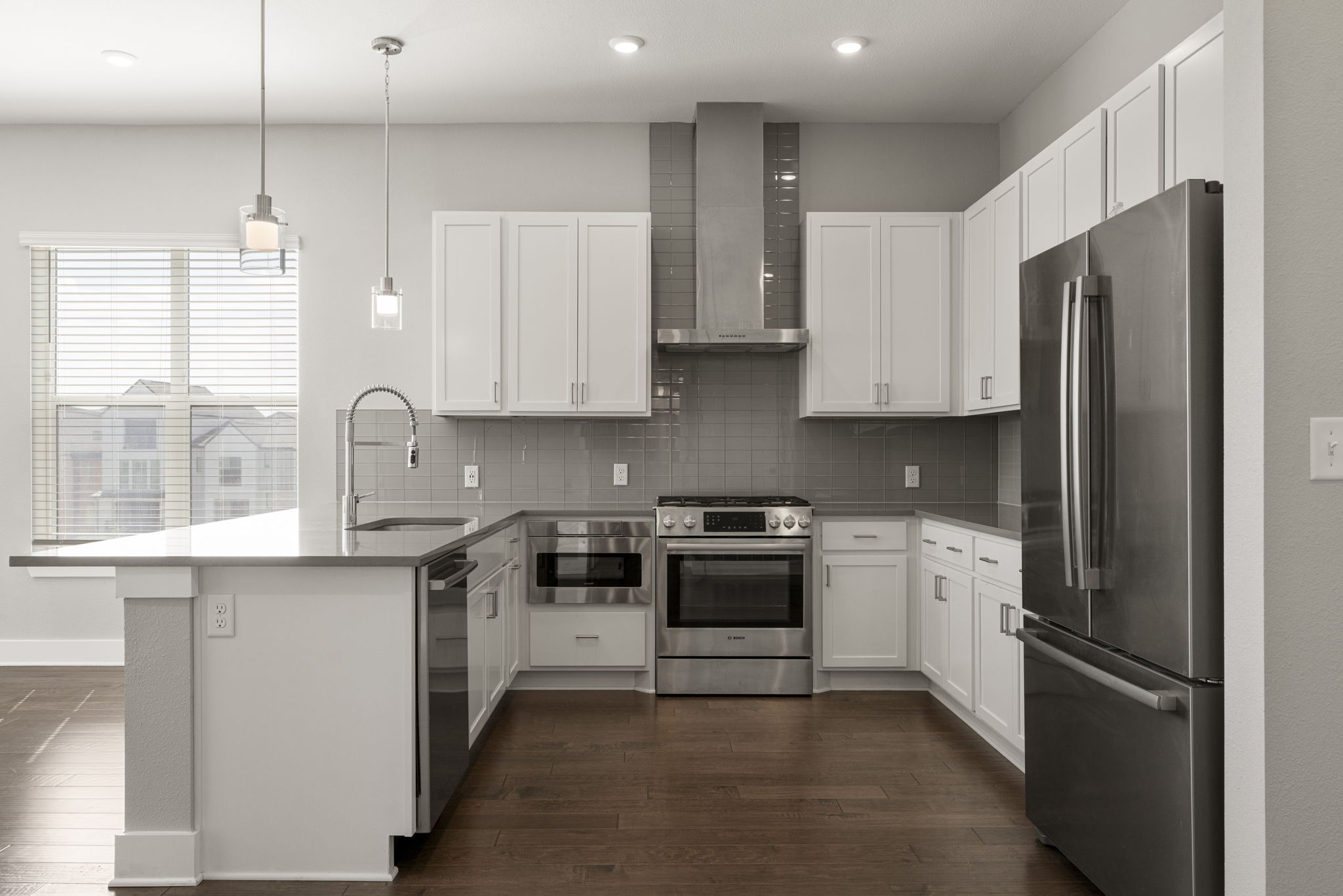 4501 Jackson Avenue, Unit 5205 Austin, TX 78731 - Photo 5 of 40 Kitchen featuring stainless steel appliances, white cabinets, dark wood-style floors, and a peninsula