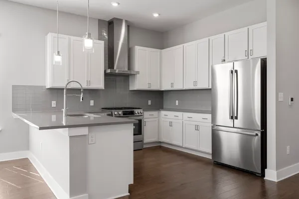 a kitchen with stainless steel appliances granite countertop a refrigerator sink and stove