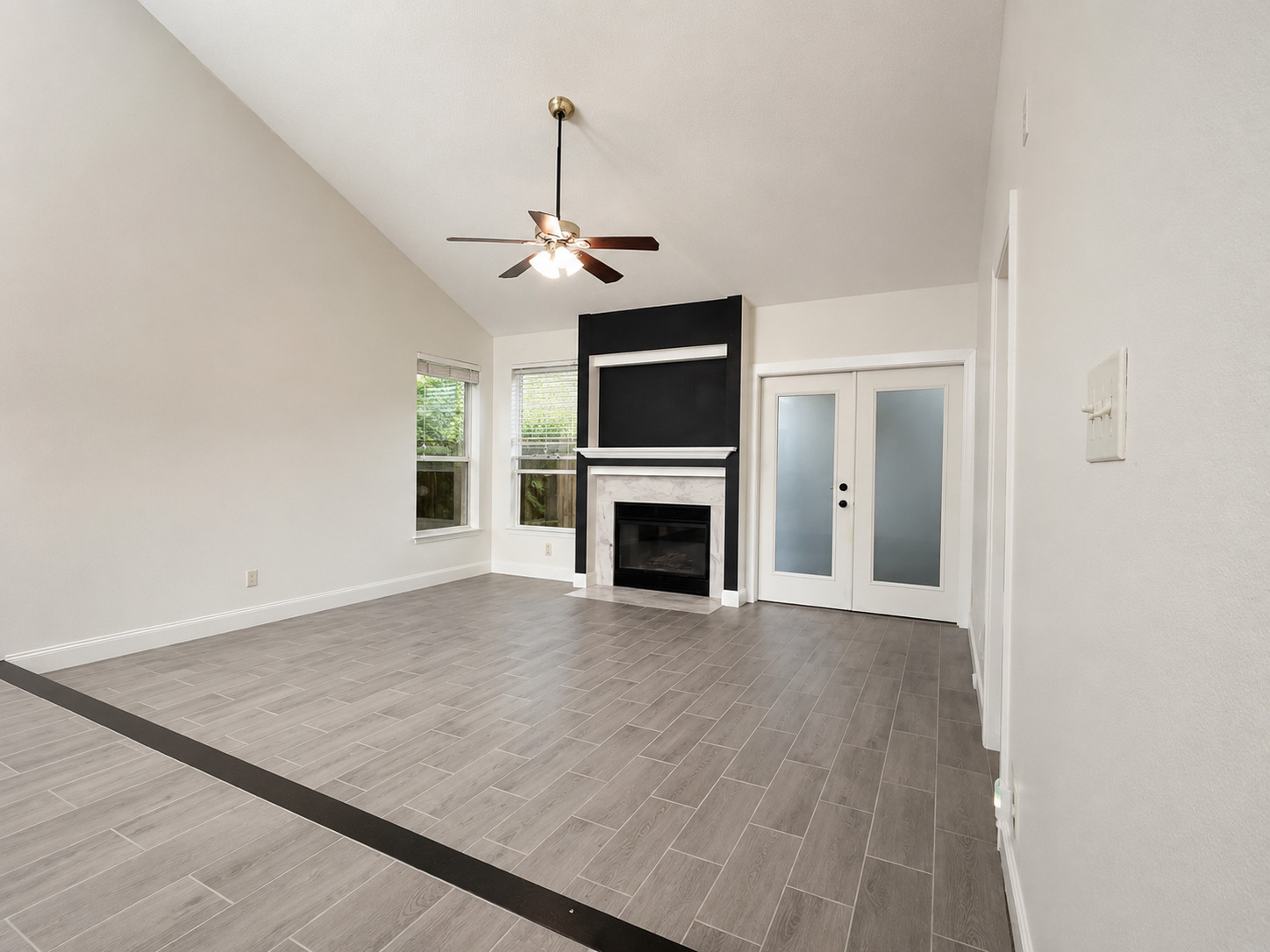 5611 Meadow Crest Austin, TX 78744 - Photo 8 of 29 A striking fireplace grounds this bright living space with vaulted ceilings and tile flooring.