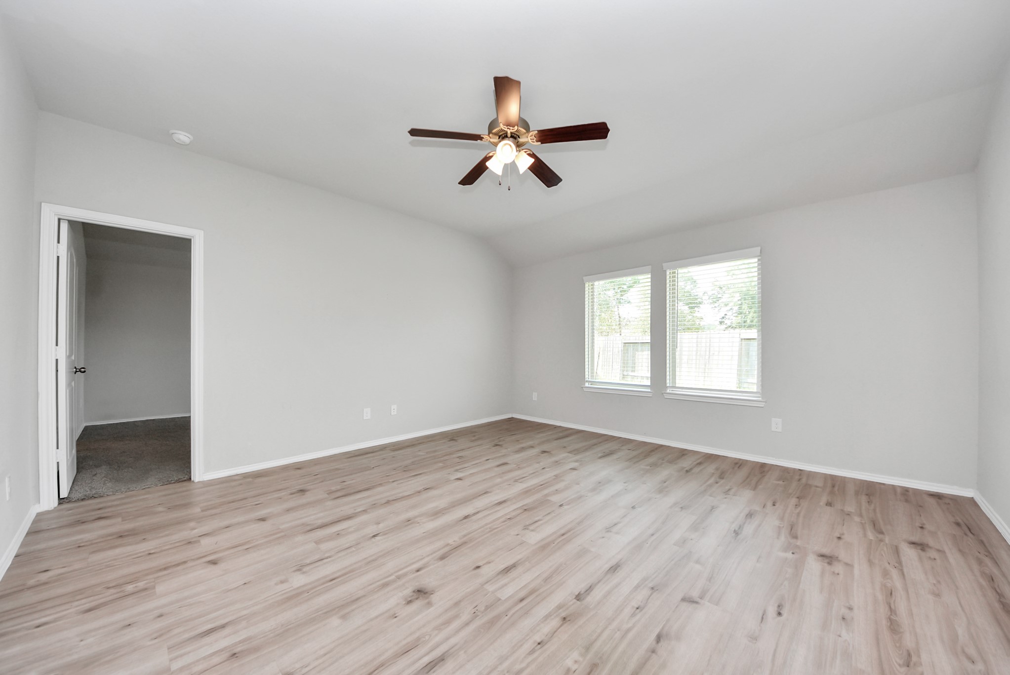 3305 Jagged Crow Lane Conroe, TX 77301 - Photo 13 of 30 an empty room with wooden floor ceiling fan and windows