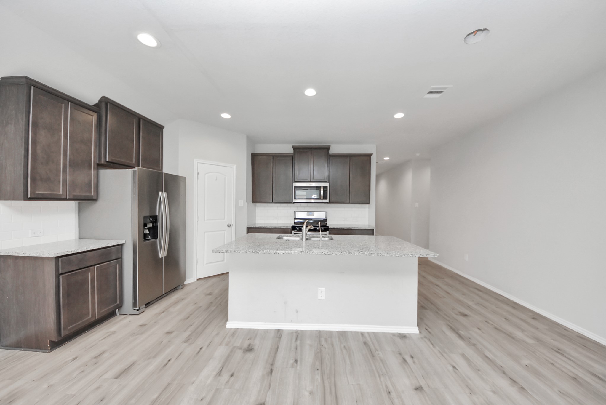 3305 Jagged Crow Lane Conroe, TX 77301 - Photo 8 of 30 a large kitchen with stainless steel appliances granite countertop a large center island a sink a stove and a refrigerator