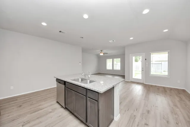 a kitchen with a sink cabinets and wooden floor