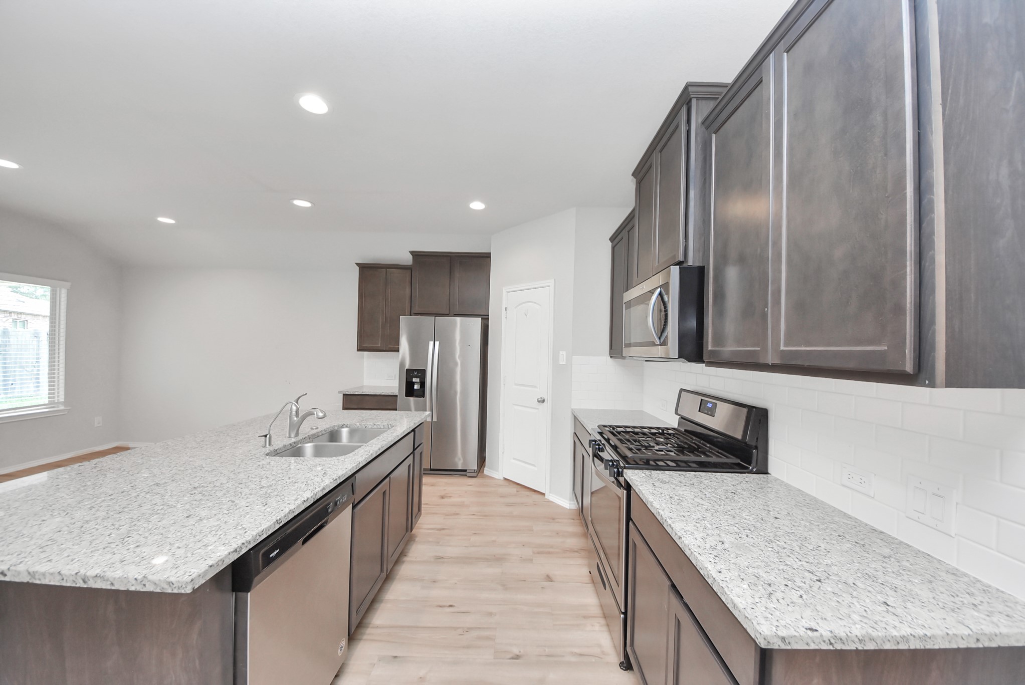 3305 Jagged Crow Lane Conroe, TX 77301 - Photo 10 of 30 a kitchen with stainless steel appliances granite countertop a sink stove and refrigerator