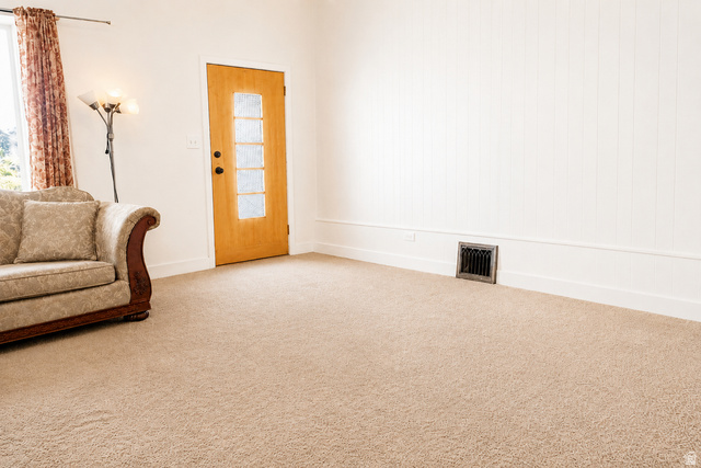 69 South Main Street Manti, UT 84642 - Photo 27 of 44 Interior room featuring light-toned carpeting, white vertical plank wall paneling, and a natural wood door with frosted glass inserts