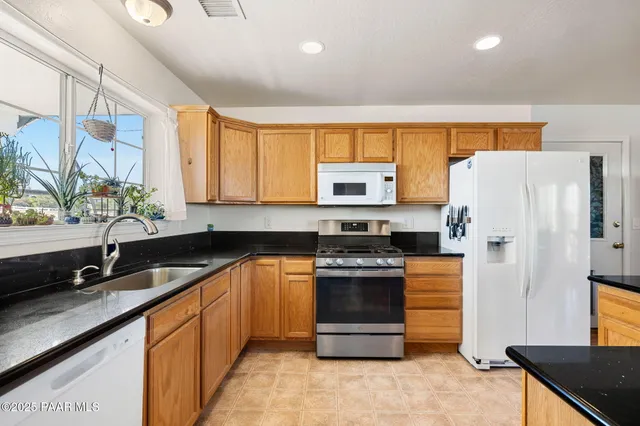 a kitchen with stainless steel appliances a refrigerator sink stove and microwave