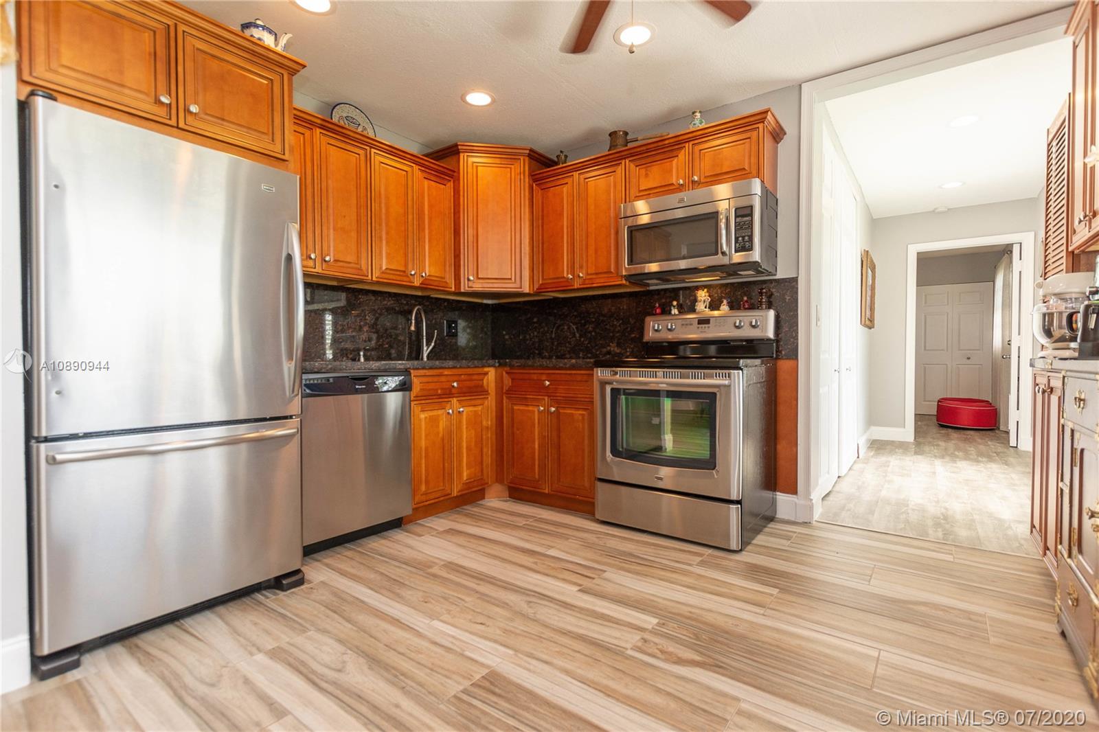 9254 Gettysburg Road Boca Raton, FL 33434 - Photo 15 of 49 a kitchen with stainless steel appliances granite countertop a refrigerator a stove a sink and a microwave