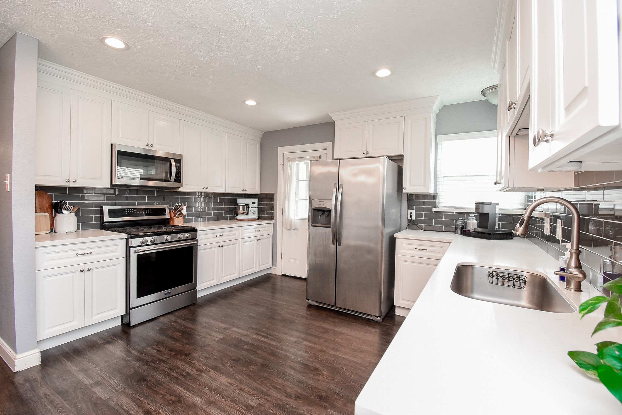 5911 Butterfly Circle Pasadena, TX 77505 - Photo 14 of 45 a kitchen with granite countertop a refrigerator a stove top oven a sink and dishwasher with wooden floor