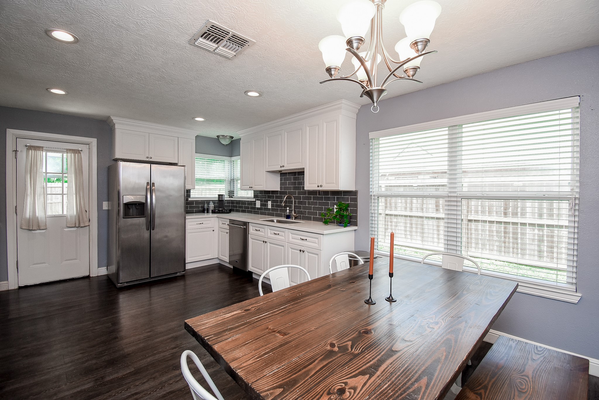 5911 Butterfly Circle Pasadena, TX 77505 - Photo 20 of 45 a kitchen with stainless steel appliances granite countertop a refrigerator a sink dishwasher a stove a dining table and chairs with wooden floor
