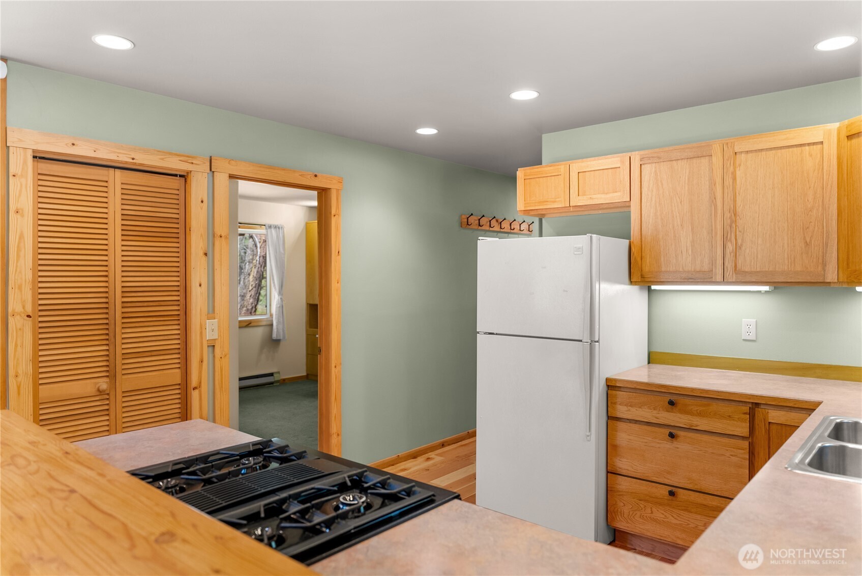 651 Lost River Road Mazama, WA 98833 - Photo 27 of 38 a kitchen with wooden cabinets and white appliances
