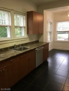a kitchen with a sink a counter top and windows