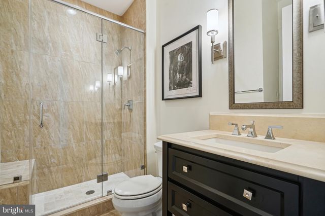 a bathroom with a granite countertop sink a toilet and a mirror