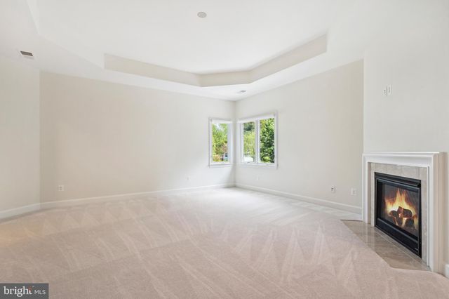 an empty room with windows and fireplace