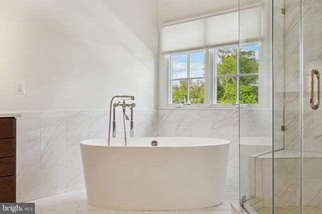a bathroom with a tub sink shower and mirror