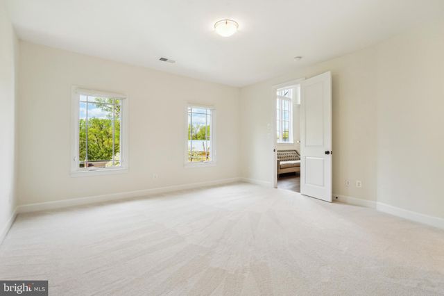 a view of empty room with wooden floor and windows