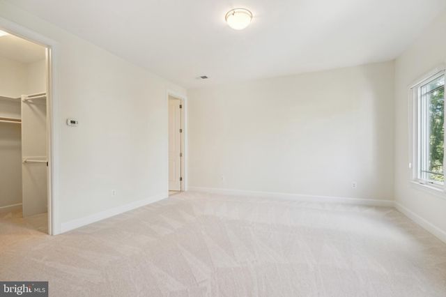 a view of an empty room with kitchen and a fireplace