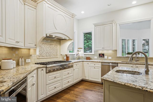 a kitchen with granite countertop a sink stainless steel appliances and cabinets