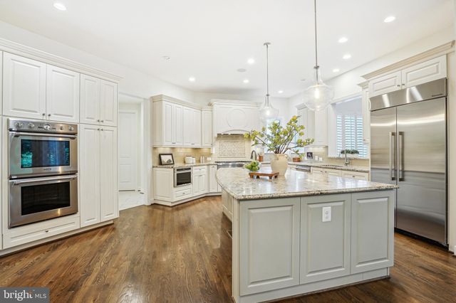 a kitchen with kitchen island granite countertop a sink stainless steel appliances and cabinets