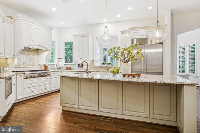 a kitchen with stainless steel appliances granite countertop a sink a stove and cabinets