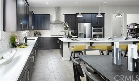 32511 Parker Street Menifee, CA 92584 - Photo 2 of 6 an open kitchen with kitchen island wooden cabinets and stainless steel appliances