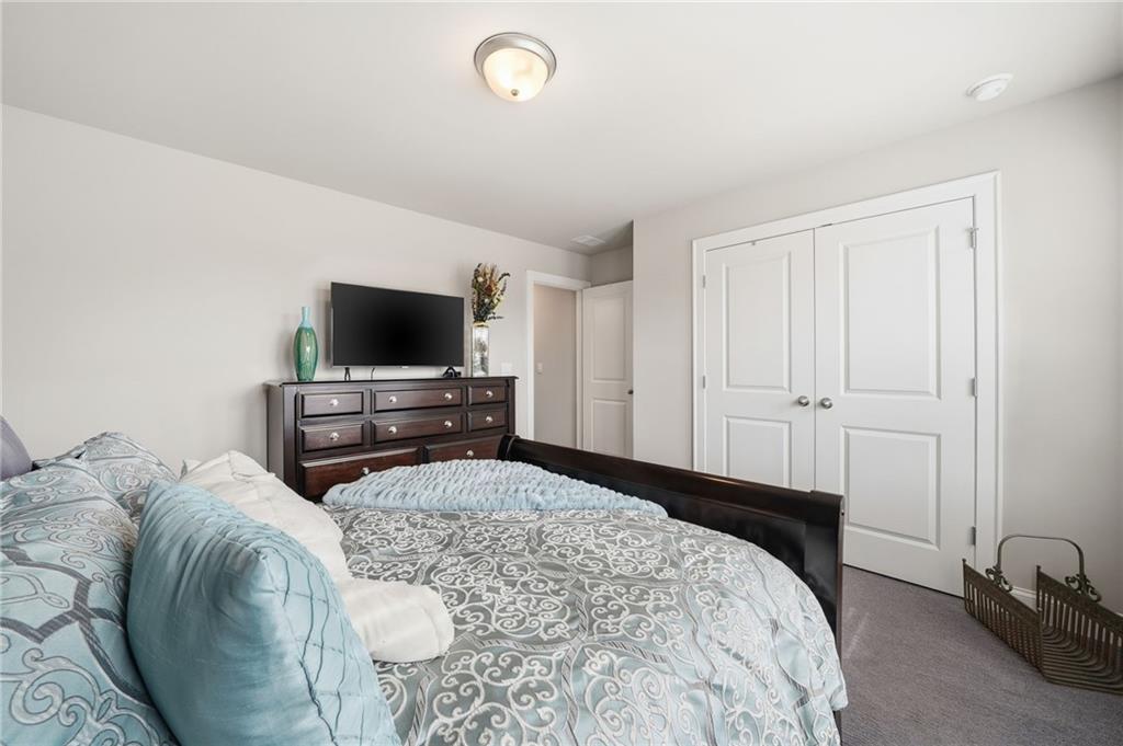 515 Cobblestone Circle Canton, GA 30115 - Photo 32 of 45 a bedroom with a bed and a flat screen tv