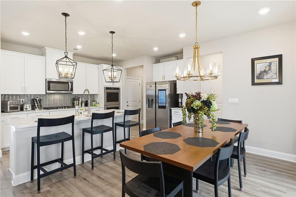 515 Cobblestone Circle Canton, GA 30115 - Photo 10 of 45 a kitchen with a dining table chairs stainless steel appliances and cabinets