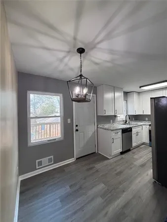 a large kitchen with a center island wooden floor and stainless steel appliances