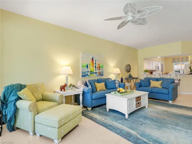 a living room with furniture kitchen view and a chandelier