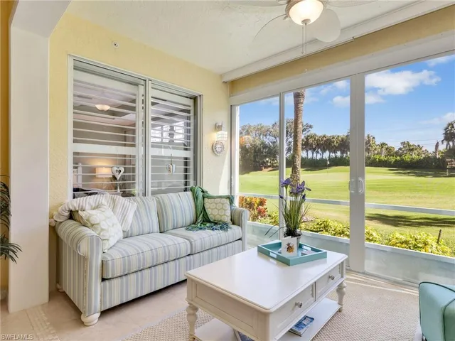 a living room with furniture and floor to ceiling windows