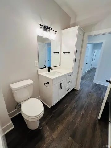 a bathroom with a granite countertop toilet sink and mirror