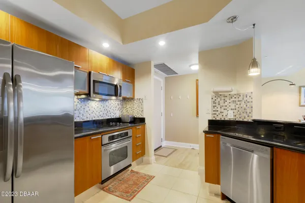 a kitchen with granite countertop a sink and stainless steel appliances