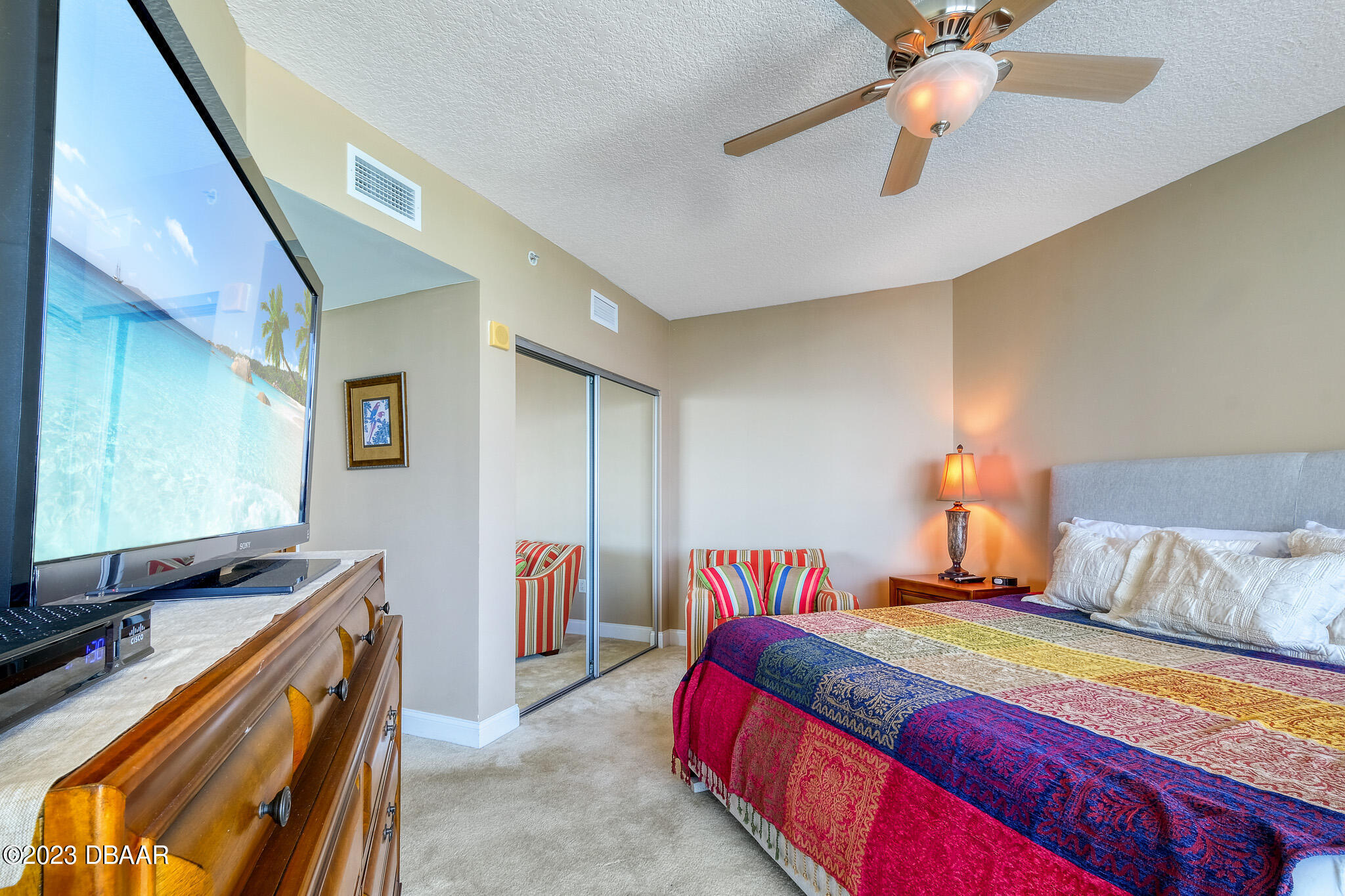 241 Riverside Drive, Unit 808 Holly Hill, FL 32117 - Photo 18 of 41 a bedroom with bed and a flat screen tv