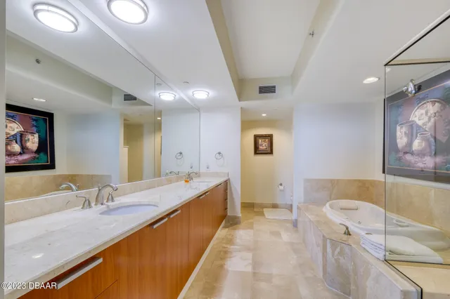 a spacious bathroom with a tub double sink and mirror