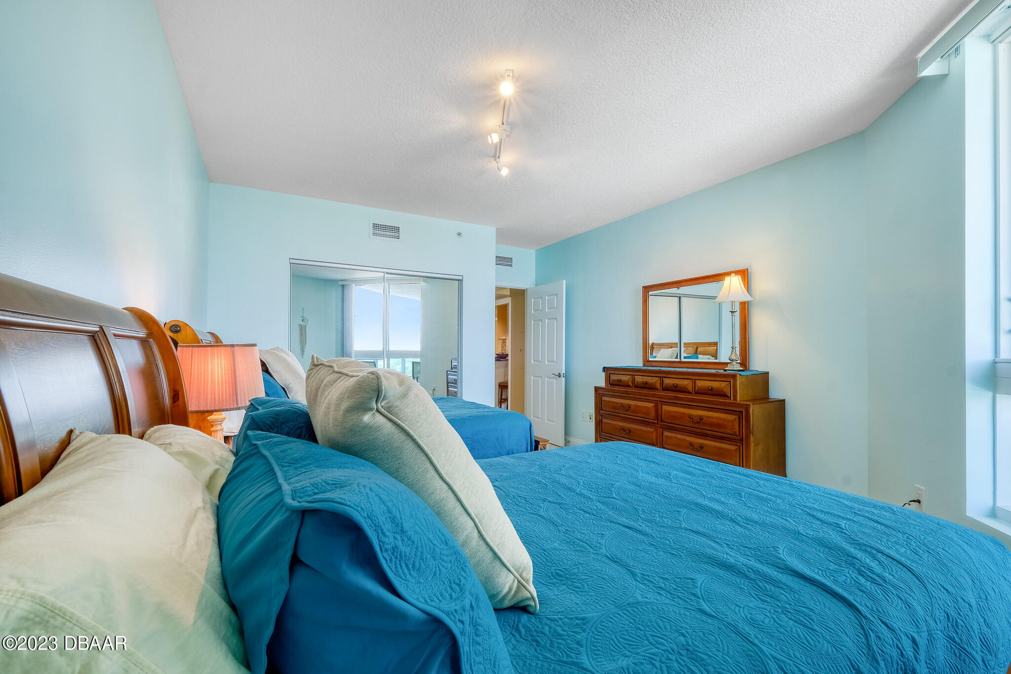 241 Riverside Drive, Unit 808 Holly Hill, FL 32117 - Photo 24 of 41 a bed room with a bed and a chandelier
