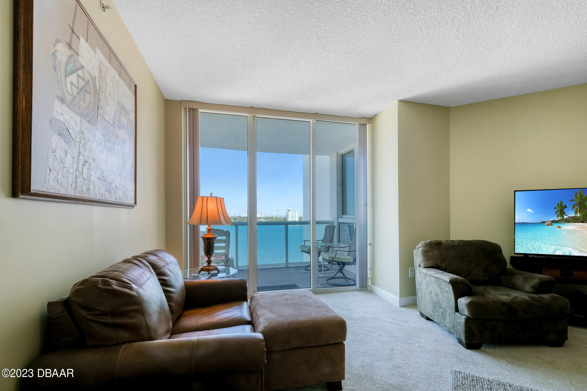 241 Riverside Drive, Unit 808 Holly Hill, FL 32117 - Photo 8 of 41 a living room with furniture and a lamp