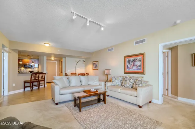 a living room with furniture and a dining table with wooden floor