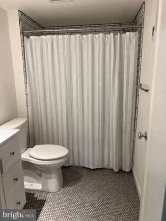 a bathroom with a toilet and a shower curtain