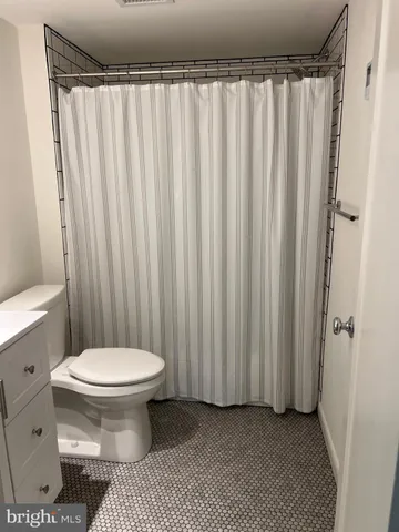 a bathroom with a toilet and a shower curtain