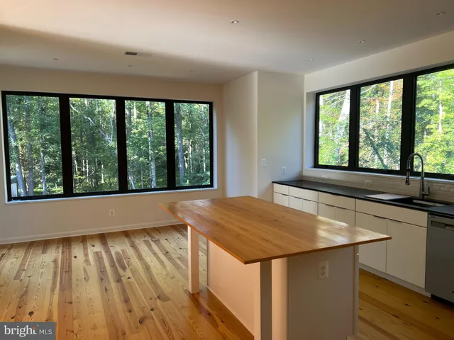 a view of a kitchen with wooden floor and a sink