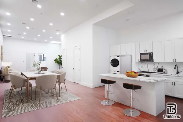 a kitchen with stainless steel appliances a table and chairs in it