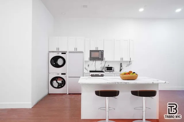 a kitchen with a sink a stove and white cabinets