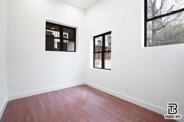 an empty room with a window and wooden floor