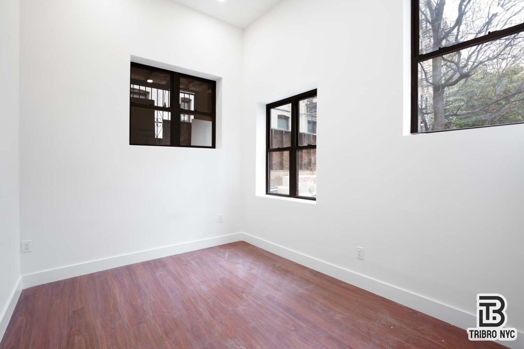 217 South 4th Street, Unit LOFT1 Brooklyn, NY 11211 - Photo 9 of 12 an empty room with a window and wooden floor