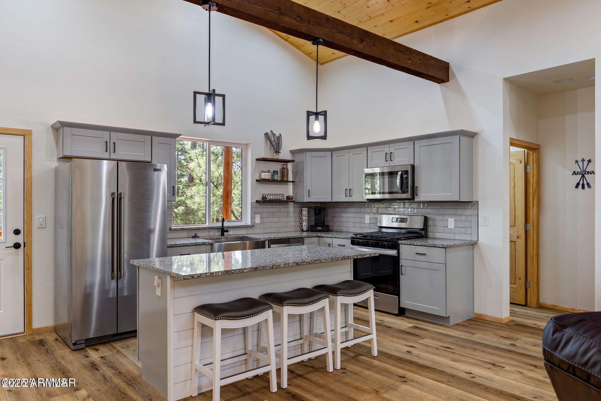a kitchen with stainless steel appliances granite countertop a stove and a refrigerator