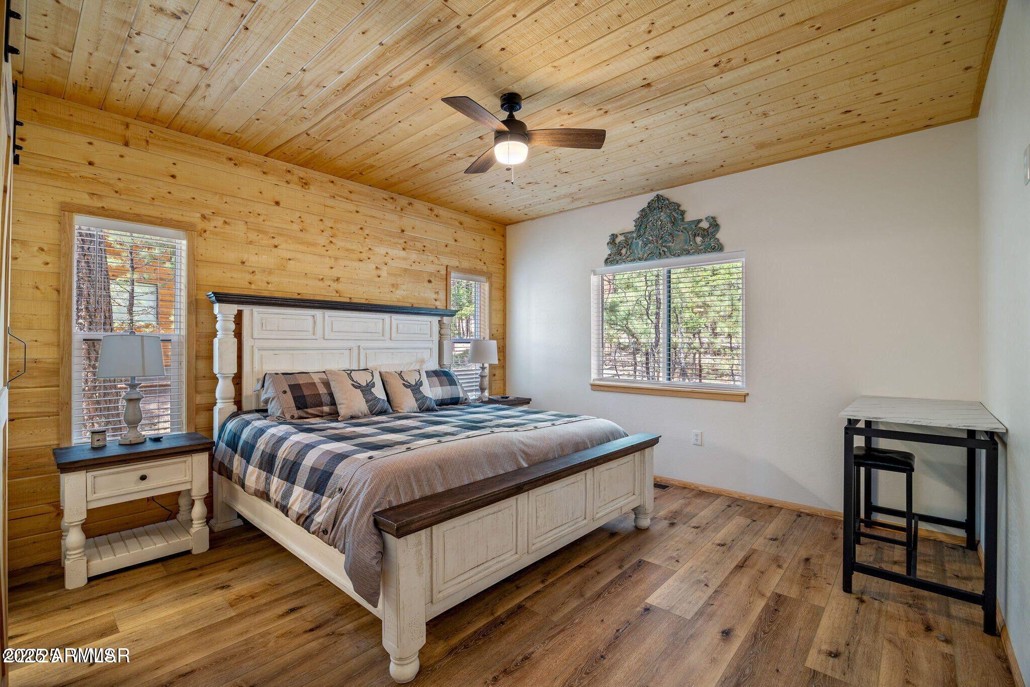 26 County Road 2067 Alpine, AZ 85920 - Photo 7 of 33 a bedroom with a bed and a table with wooden floor