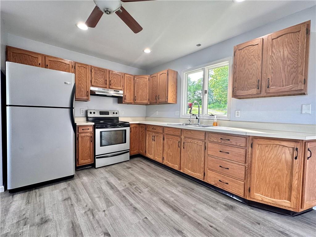 241 Countryview Road Slippery Rock, PA 16057 - Photo 3 of 24 a kitchen with granite countertop a refrigerator a sink dishwasher a stove and white cabinets with wooden floor